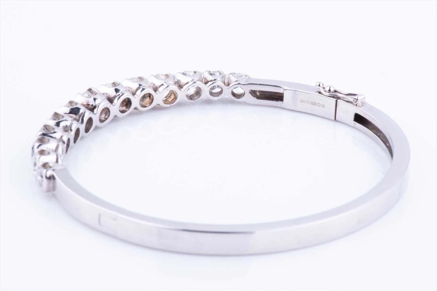 An 18ct white gold and diamond hinged bangle, set with thirteen round brilliant-cut graduated - Image 3 of 6