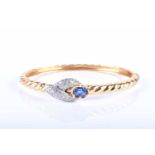 A yellow metal, diamond, and sapphire bangle, the mixed oval-cut blue sapphire in a pinched bezel