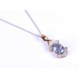 A 9ct yellow gold and blue topaz pendant, centred with a mixed oval-cut blue topaz, set to the top