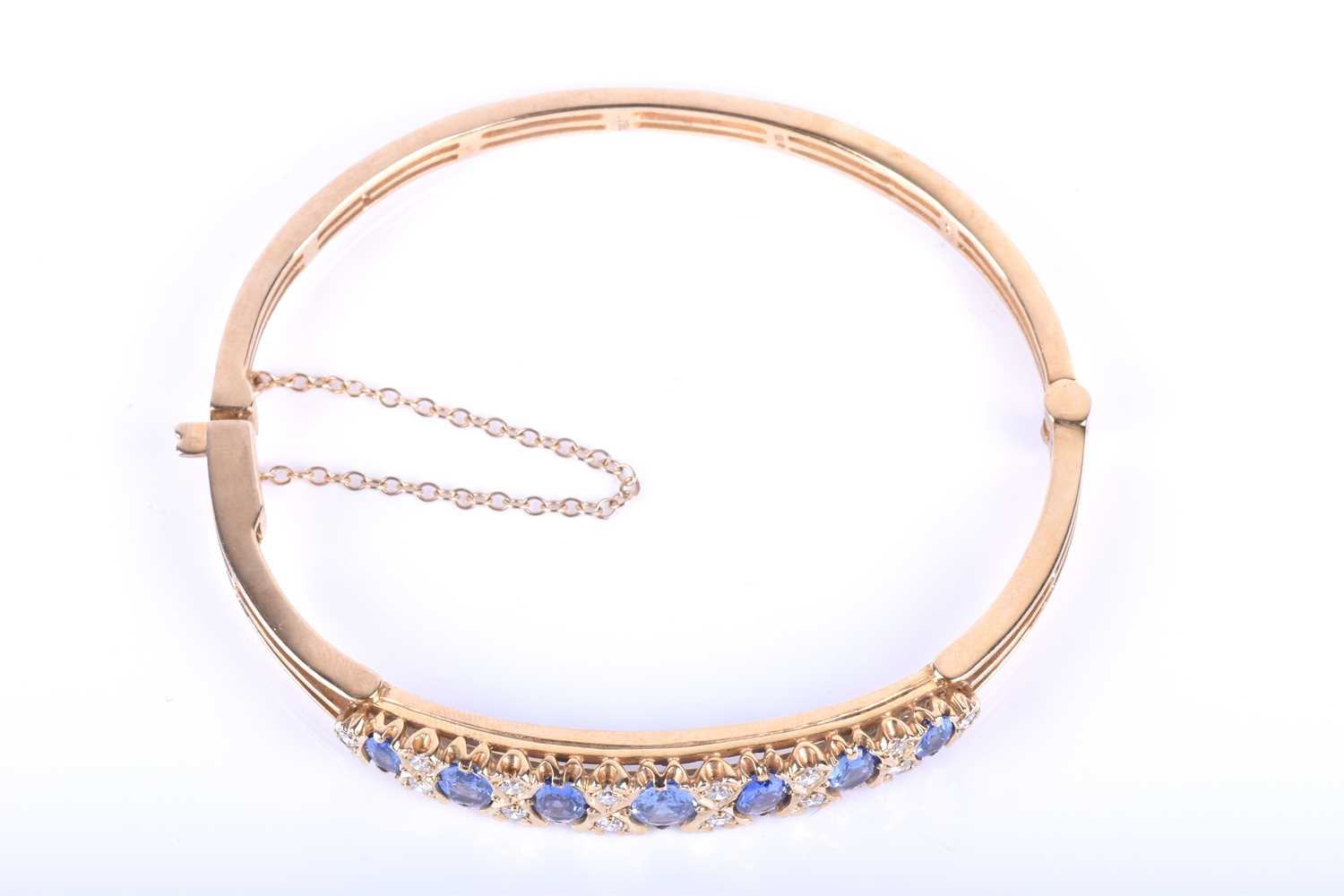 A 9ct yellow gold, diamond and sapphire bangle, set with seven graduated mixed oval cut blue - Image 3 of 6