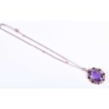 A late 19th / early 20th century yellow metal, amethyst and split seed pearl pendant, set with a