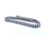 An 18t white gold and diamond tennis bracelet, set with 66 princess cut diamonds of H colour and VS2