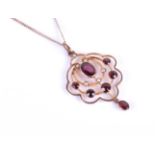 An early 20th century 9ct yellow gold, garnet and split seed pearl pendant, of scalloped openwork