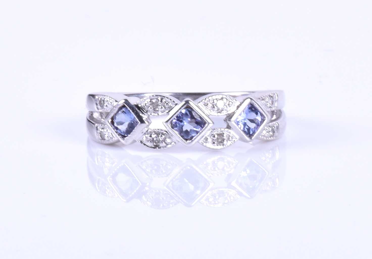A diamond and tanzanite ring, the openwork mount set with square-cut pale blue tanzanites,