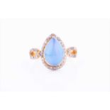 A silver gilt opal and diamond ring, set with a pear-shaped cabochon opal within a border and