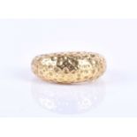 A 1970s Modernist style 18ct gold ring, the bombe-style ring with beaten and planished finish,