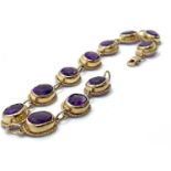A 9ct yellow gold and amethyst bracelet, set with 11 rub-over set oval amethysts. 10.78 grams, 20 cm