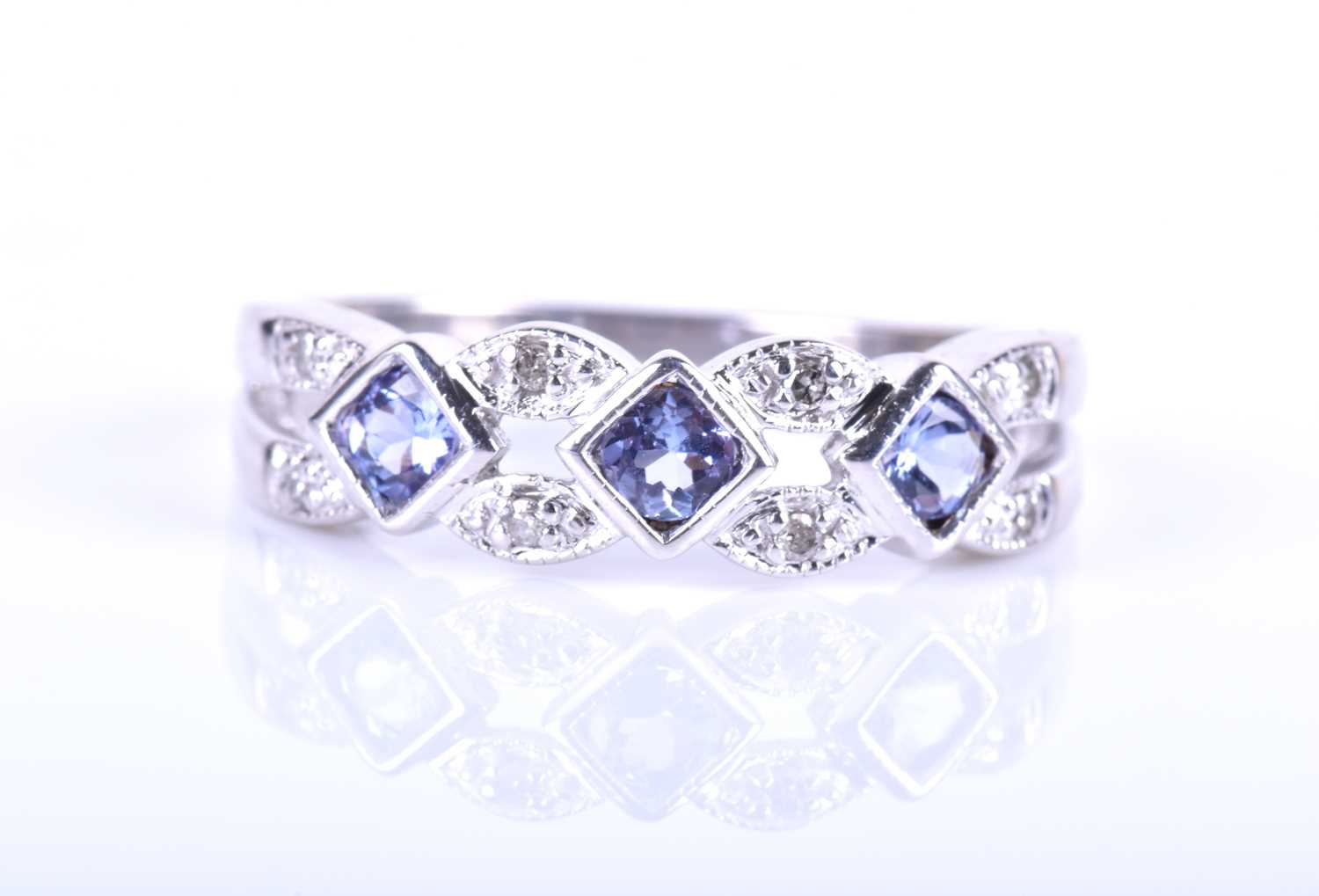 A diamond and tanzanite ring, the openwork mount set with square-cut pale blue tanzanites, - Image 2 of 5