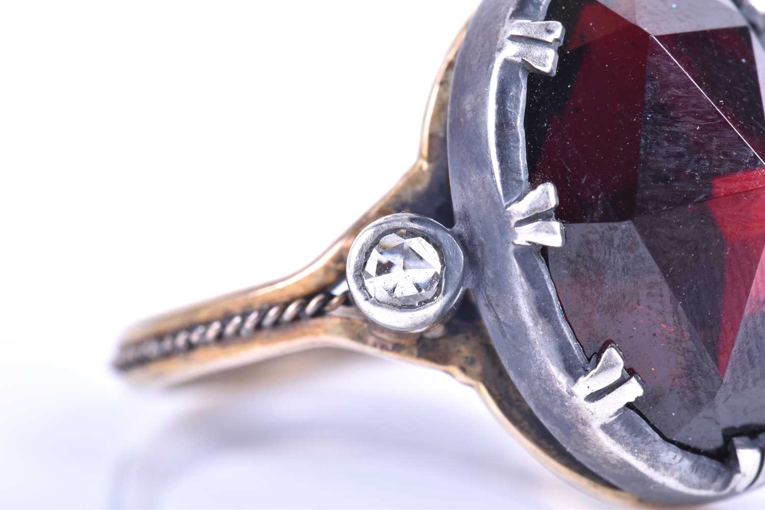 A silver, gold and garnet cocktail ring, set with a large oval rose-cut garnet, set in silver, - Image 8 of 10