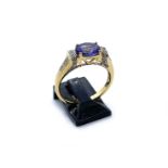 An 18ct yellow gold, tanzanite and diamond ring, the central oval tanzanite of good colour with 8-
