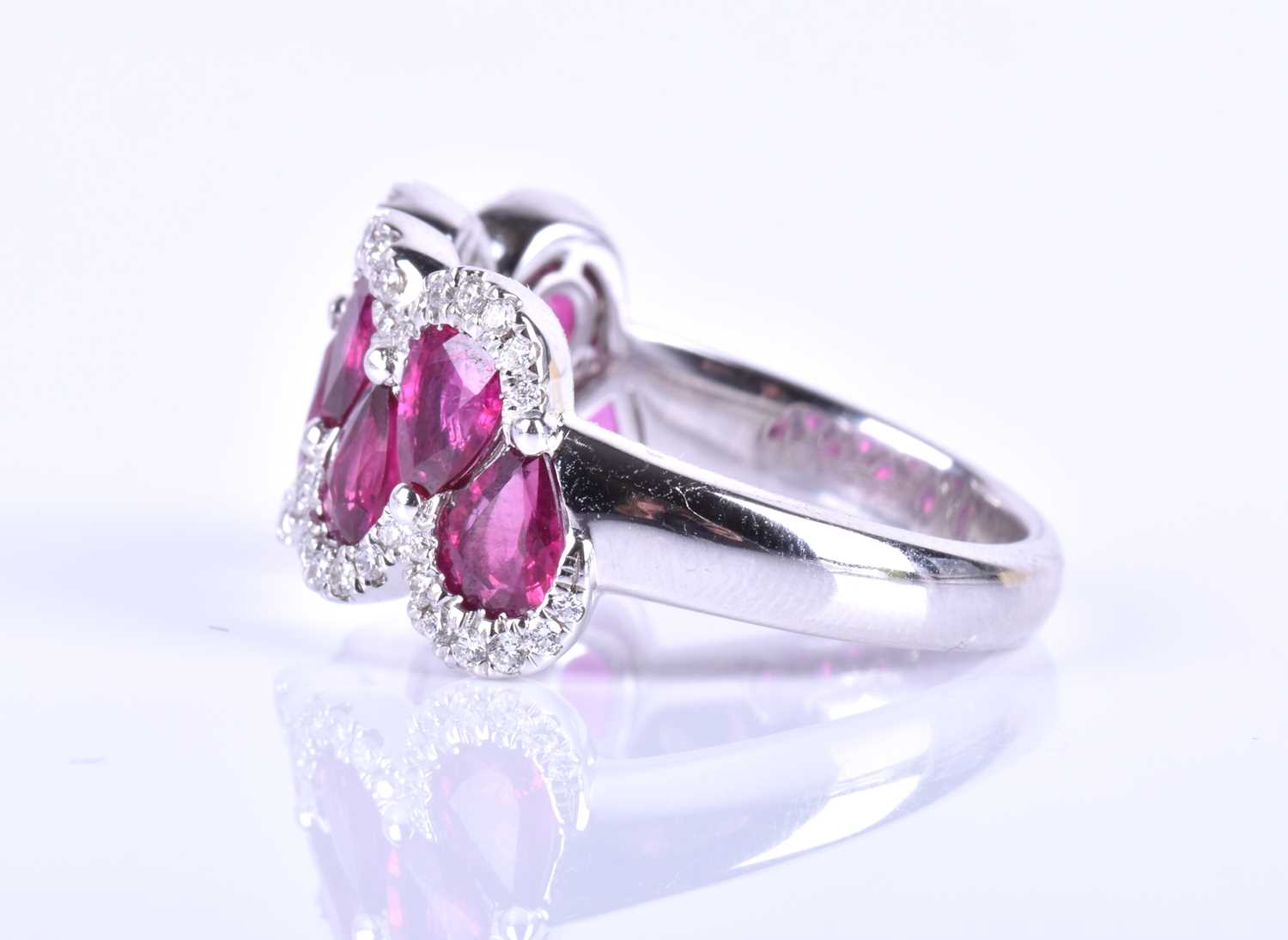 An 18ct white gold, diamond and ruby ring, the rounded mount set with a row of mixed pear-cut rubies - Image 4 of 6