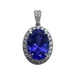 An 18ct white gold, tanzanite and diamond pendant, the central oval AAA grade intense violet blue