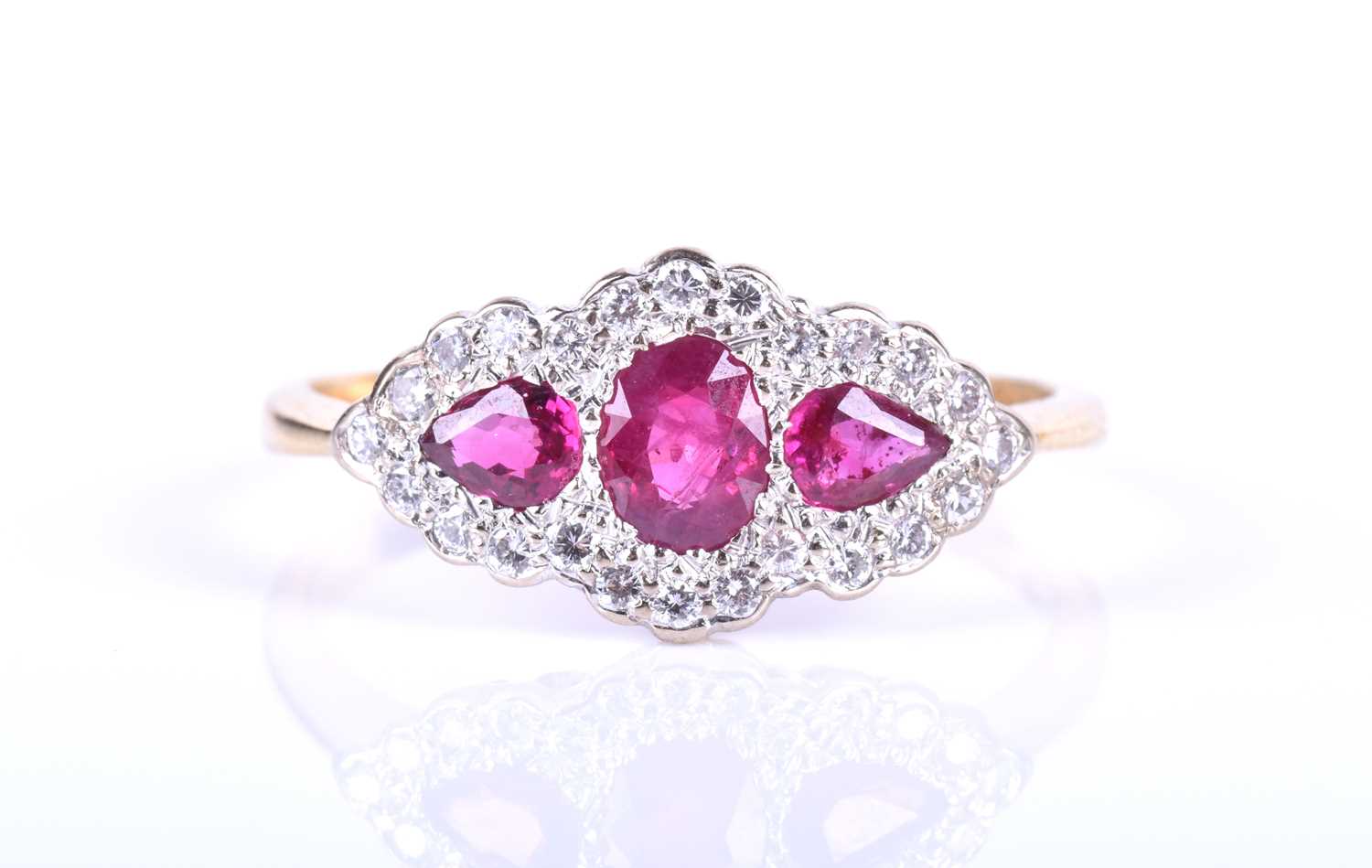 An 18ct yellow gold, diamond and ruby ring, centred with a mixed oval-cut ruby flanked with two