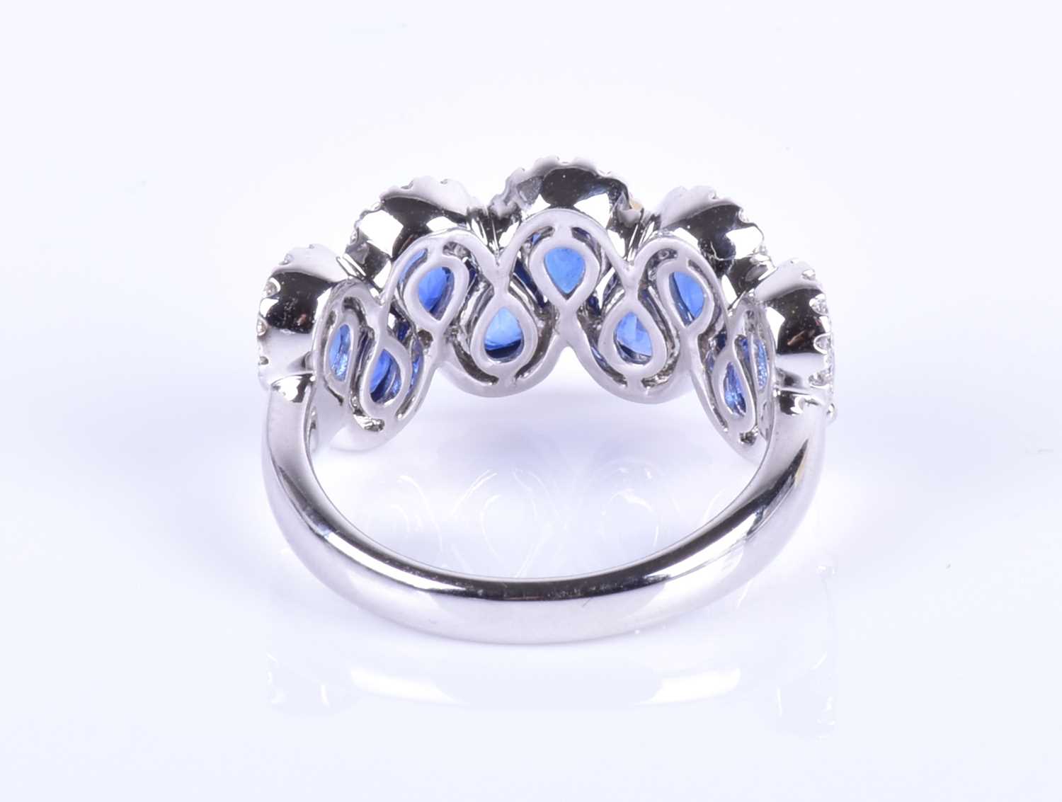 An 18ct white gold, diamond and sapphire ring, the rounded mount set with a row of mixed pear-cut - Image 7 of 8