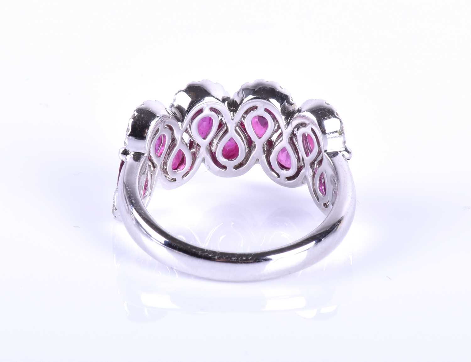 An 18ct white gold, diamond and ruby ring, the rounded mount set with a row of mixed pear-cut rubies - Image 2 of 6