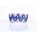 An 18ct white gold, diamond and sapphire ring, the rounded mount set with a row of mixed pear-cut