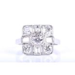 A platinum and diamond ring, in the Art Deco style, the squared mount centred with a round-cut