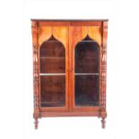 A late 19th century mahogany two-door cabinet with arched detail to glass front.