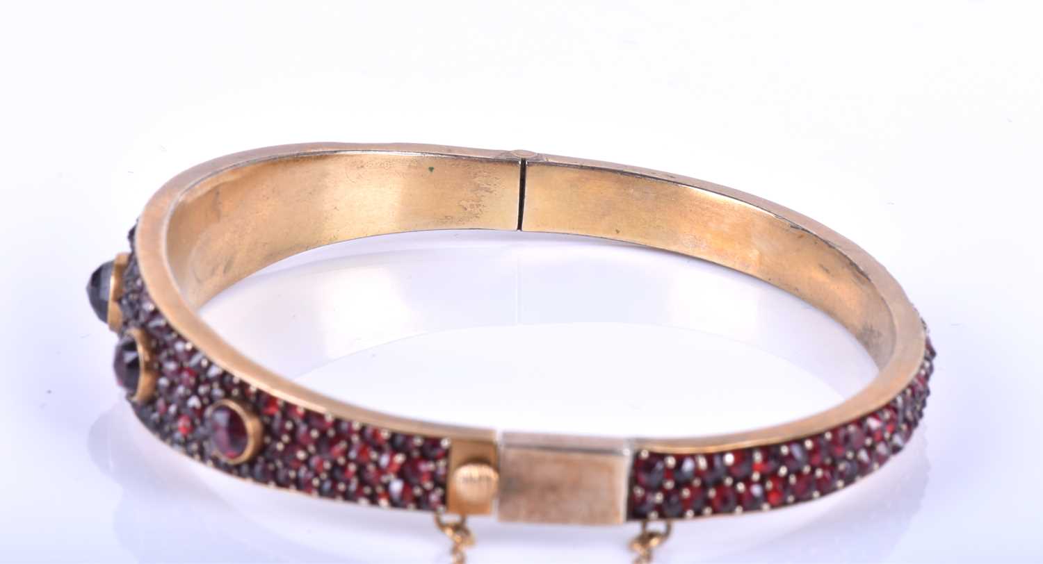 A late Victorian garnet bracelet, the gilt metal hinged bangle set with five collet-set rose-cut - Image 6 of 8