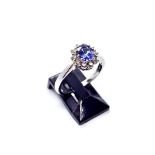 An 18ct white gold tanzanite and diamond cluster ring, the central oval claw set tanzanite