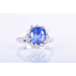 An 18ct white gold, diamond, and blue sapphire ringset with a round cushion-cut sapphire of