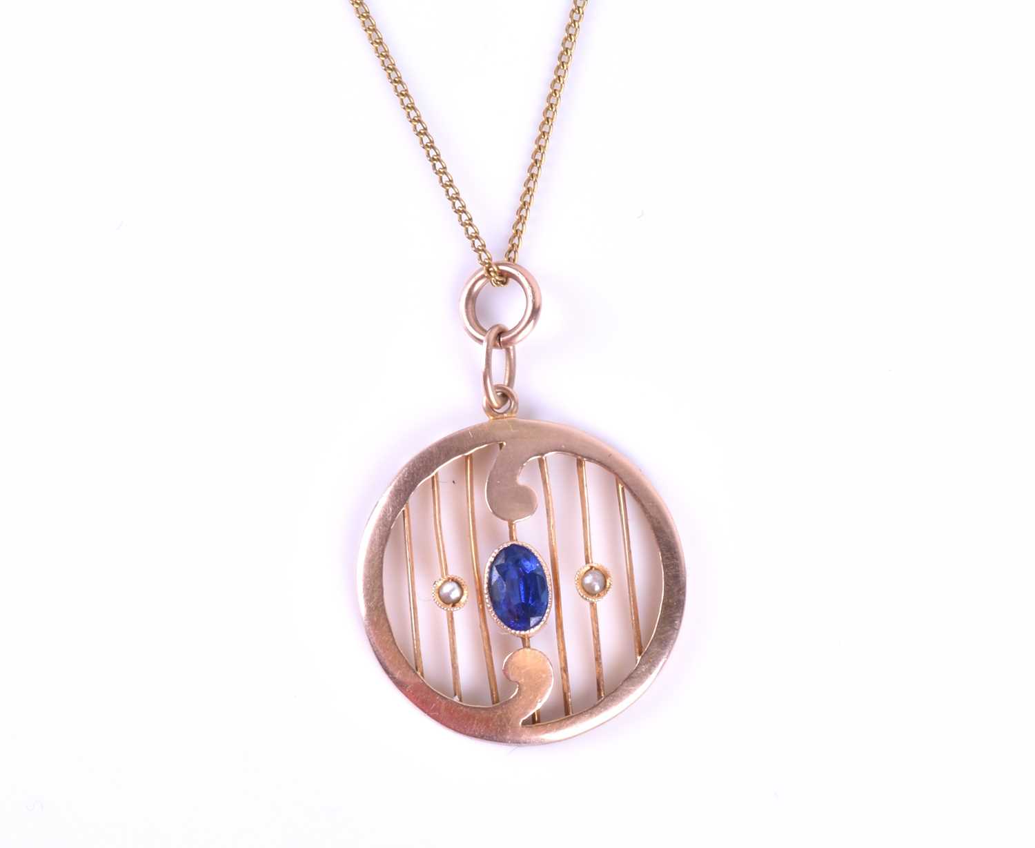 A late 19th / early 20th century yellow metal and synthetic sapphire pendant, of rounded form with