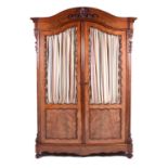 A 19th century figured mahogany two door glazed cabinet, the arched top with carved decoration, over