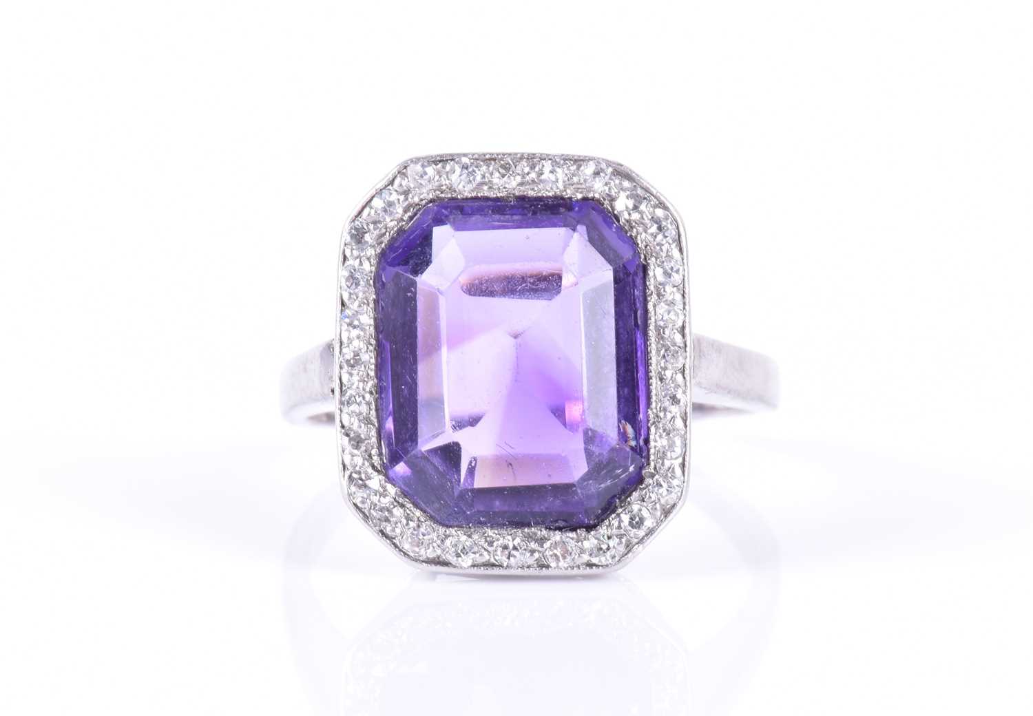 A diamond and amethyst cocktail ringin the Art Deco style, set with an emerald-cut amethyst within