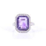 A diamond and amethyst cocktail ringin the Art Deco style, set with an emerald-cut amethyst within