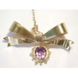 A 9ct gold bow brooch with amethyst pendant drop, with safety chain, the amethyst approximately 11mm