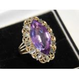 A Continental 9ct gold and amethyst cocktail ring, the marquise shape stone in open basket work