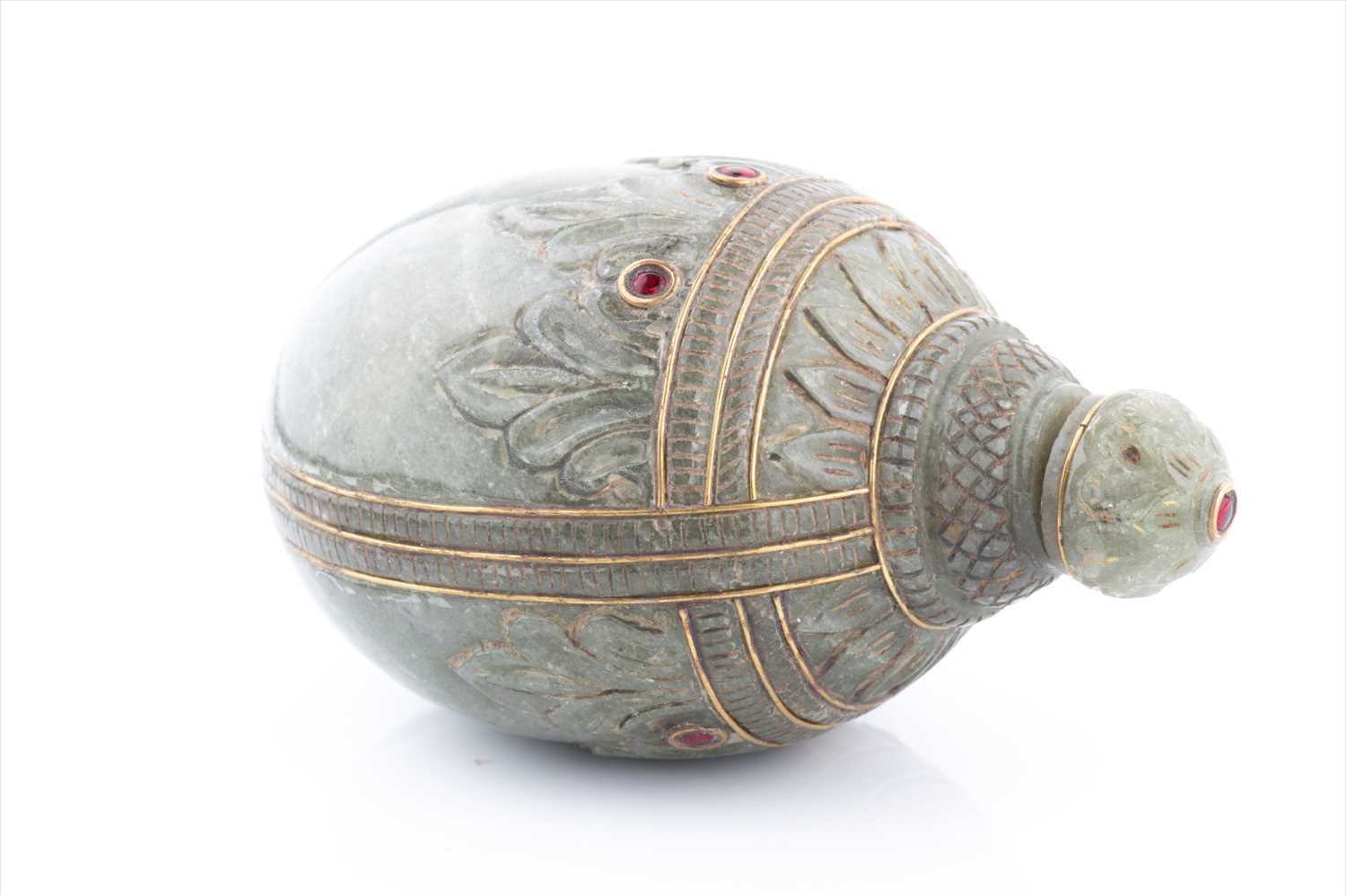 A Mughal style celadon jade scent bottle, of conch form with carved acanthus, red paste bejewelled - Image 2 of 5