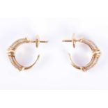 Cartier. A pair of 18ct yellow, white, and rose gold Trinity earringsof half-hoop design with coiled