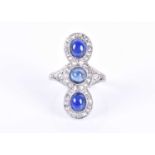 An Art Deco style diamond and sapphire ring,the triple clusters set north to south with three