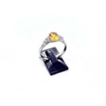An 18ct white gold orange sapphire and diamond ring, the central oval orange sapphire weighing 0.