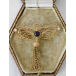 A 9ct gold Butterfly form filigree brooch, set with a central amethyst flanked by seed pearls