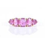 A 14ct yellow gold and pink sapphire ringset with three mixed oval-cut pink sapphires flanked with