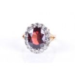 An 18ct yellow gold, diamond, and garnet cluster ringset with a mixed oval-cut garnet, within a