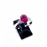 A platinum, ruby and diamond ring, the central oval ruby of good colour weighing 1.75 carat with 6