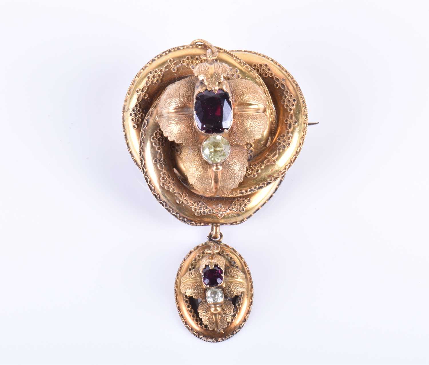 A Victorian yellow gold and garnet broochof knotted design, the mount with engraved decoration and