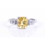 A diamond and yellow sapphire ringcentred with an emerald-cut sapphire of approximately 2.0 carats,