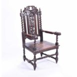 A 19th century oak armchair, the back carved with grapes and vine leaves, with barleytwist sides,