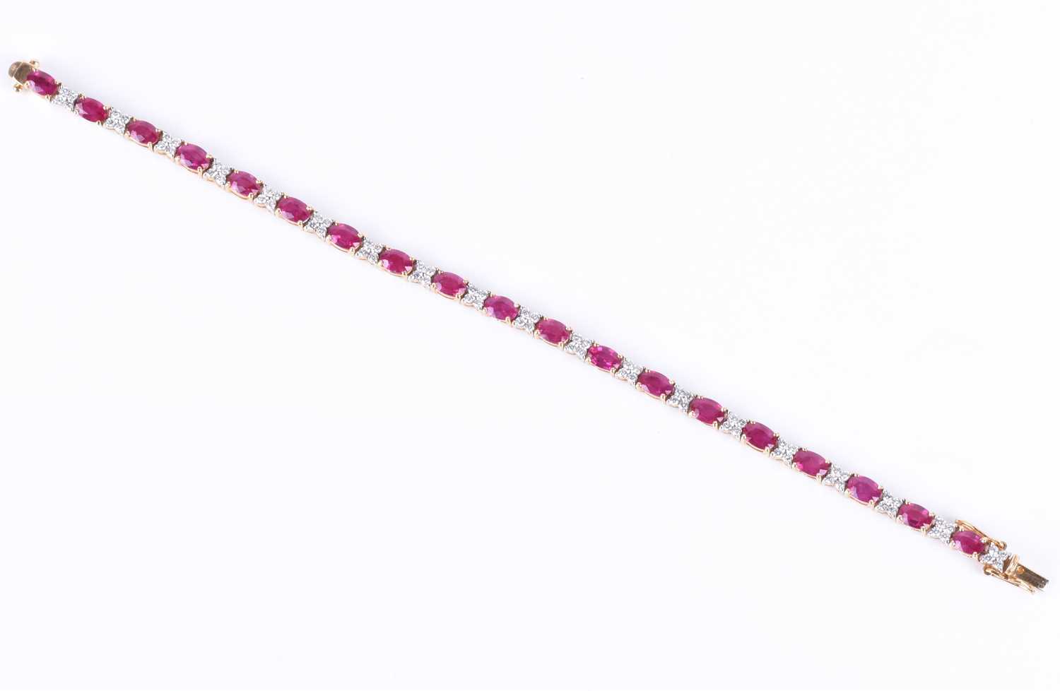 A fine 18ct yellow gold, diamond, and ruby line braceletset with nineteen mixed oval-cut rubies