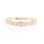 An 18ct yellow gold and diamond buckle design banglethe mount pave-set with round brilliant-cut