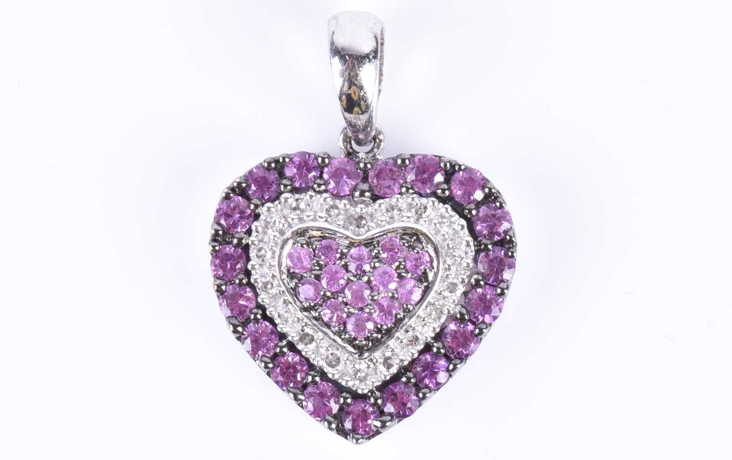 An 18ct white gold, diamond, and pink sapphire pendantof heart-shaped form, set with round-cut