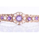 An early 20th century 9ct yellow gold, amethyst, and pearl bangleset with a floral cluster of