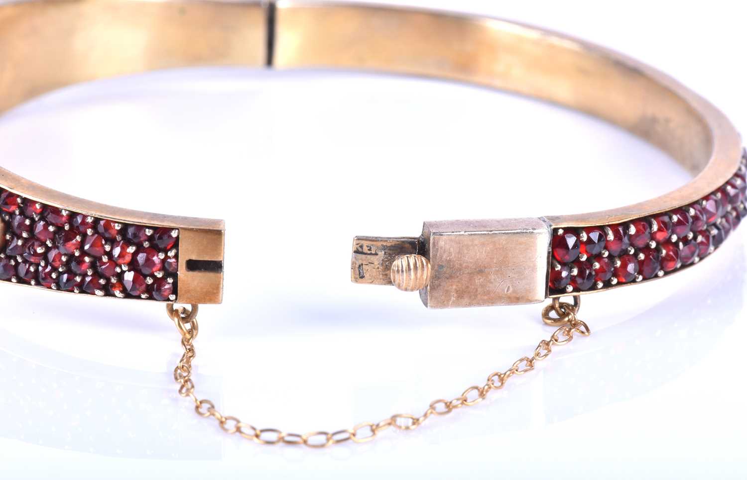 A late Victorian garnet bracelet, the gilt metal hinged bangle set with five collet-set rose-cut - Image 5 of 8