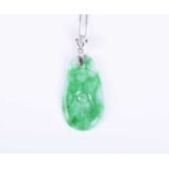 A jade and diamond pendantthe tapered oval pendant with minimal carved decoration, beneath a