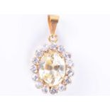 A synthetic yellow sapphire pendantset with a mixed oval-cut stone, surrounded with white gemstones,