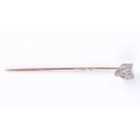 A diamond-set fox head stick pinwith demantoid garnet eyes, 7 mm wide, yellow metal pin 5.5 cm long,